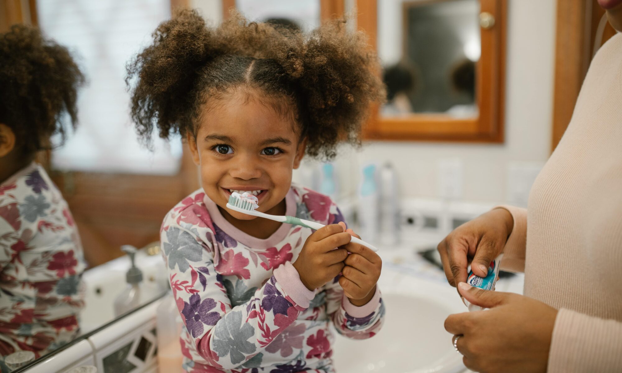 A kid brushing her teeth