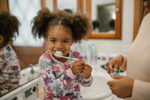 A kid brushing her teeth